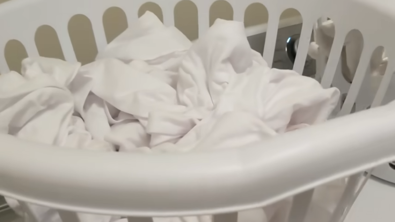 An Image of A Laundry Basket Filled with White Clothes