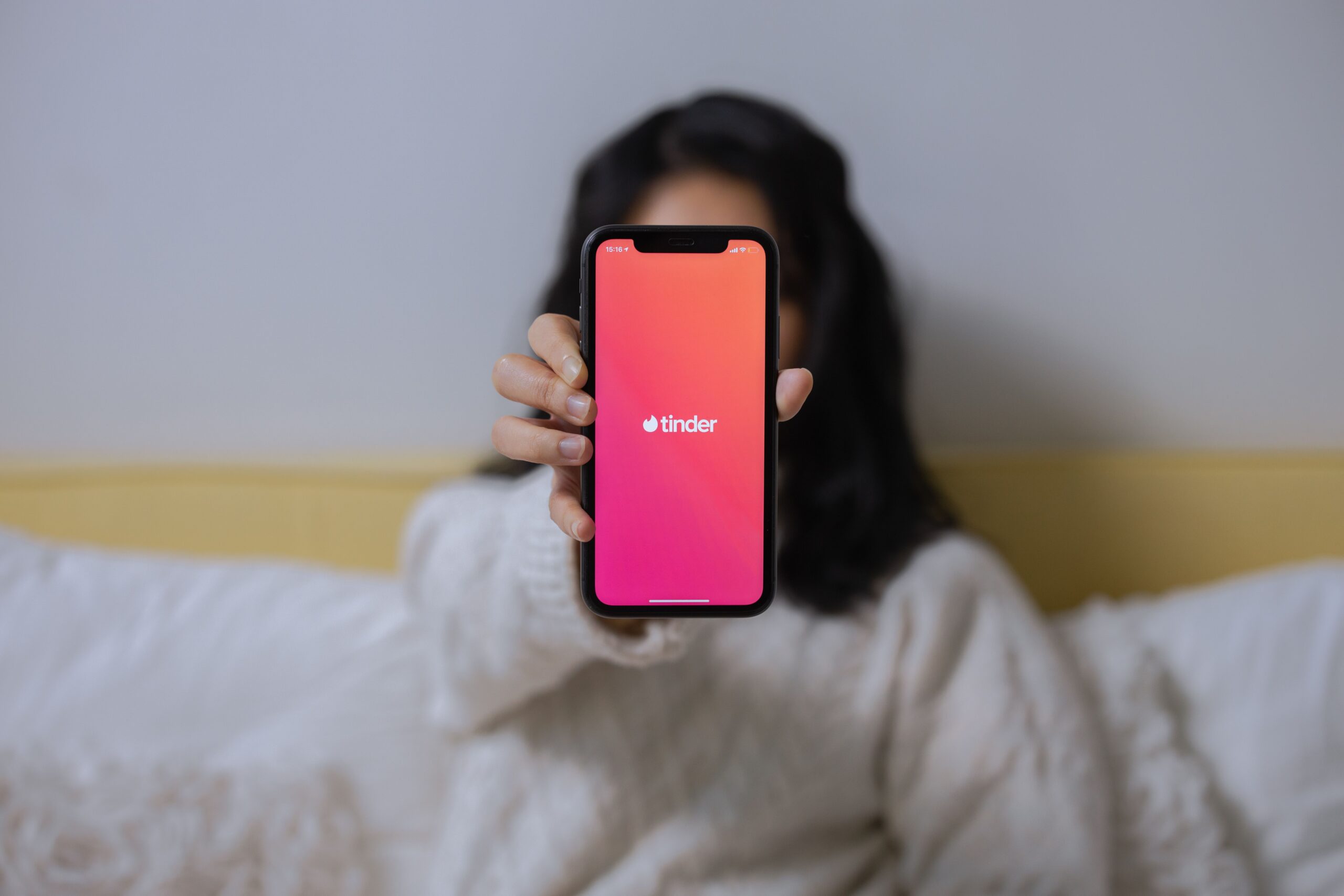 Woman browsing a dating app on her smartphone, representing modern cyber dating culture