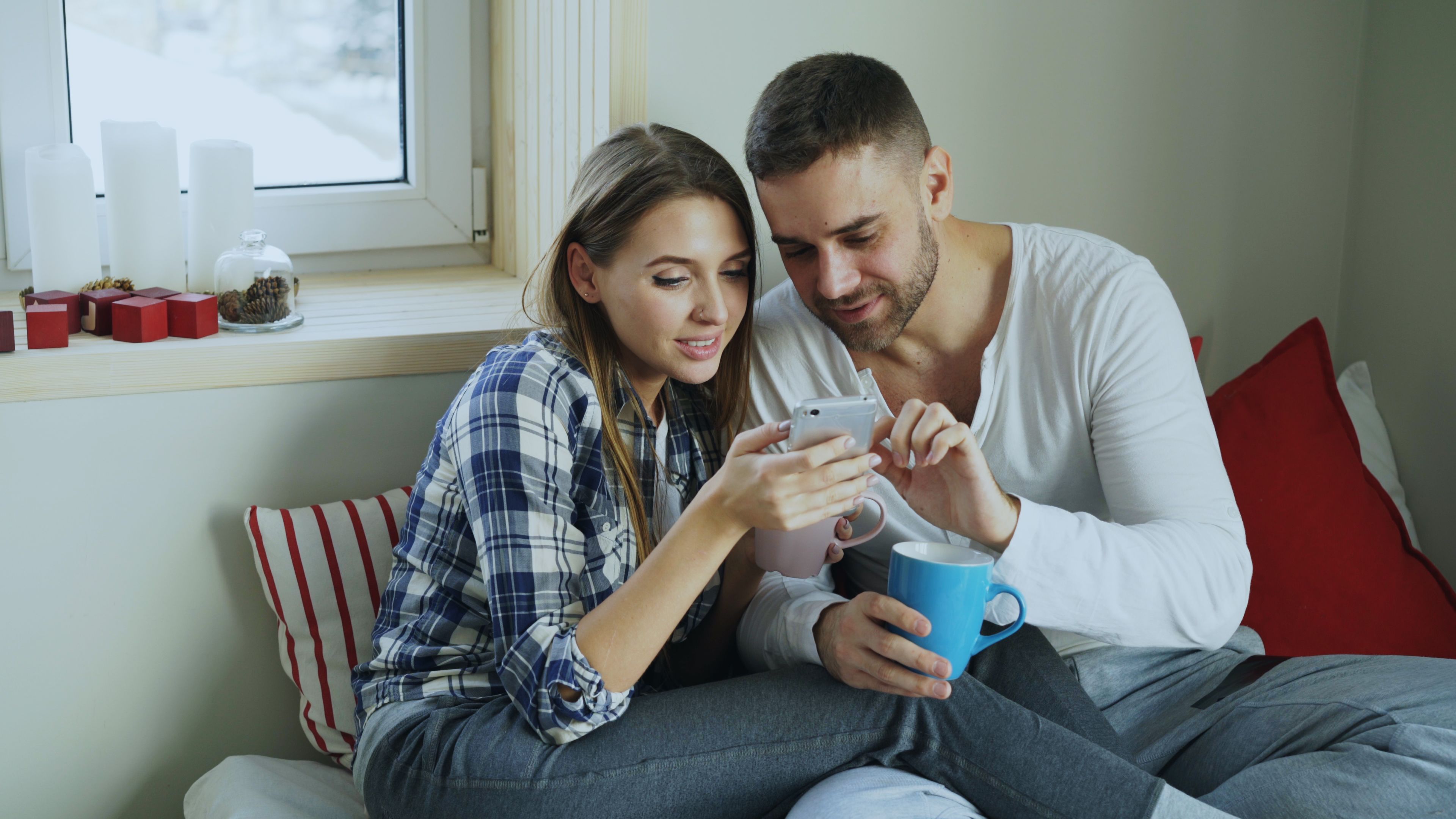 Couple relaxing together while sharing a moment on a smartphone