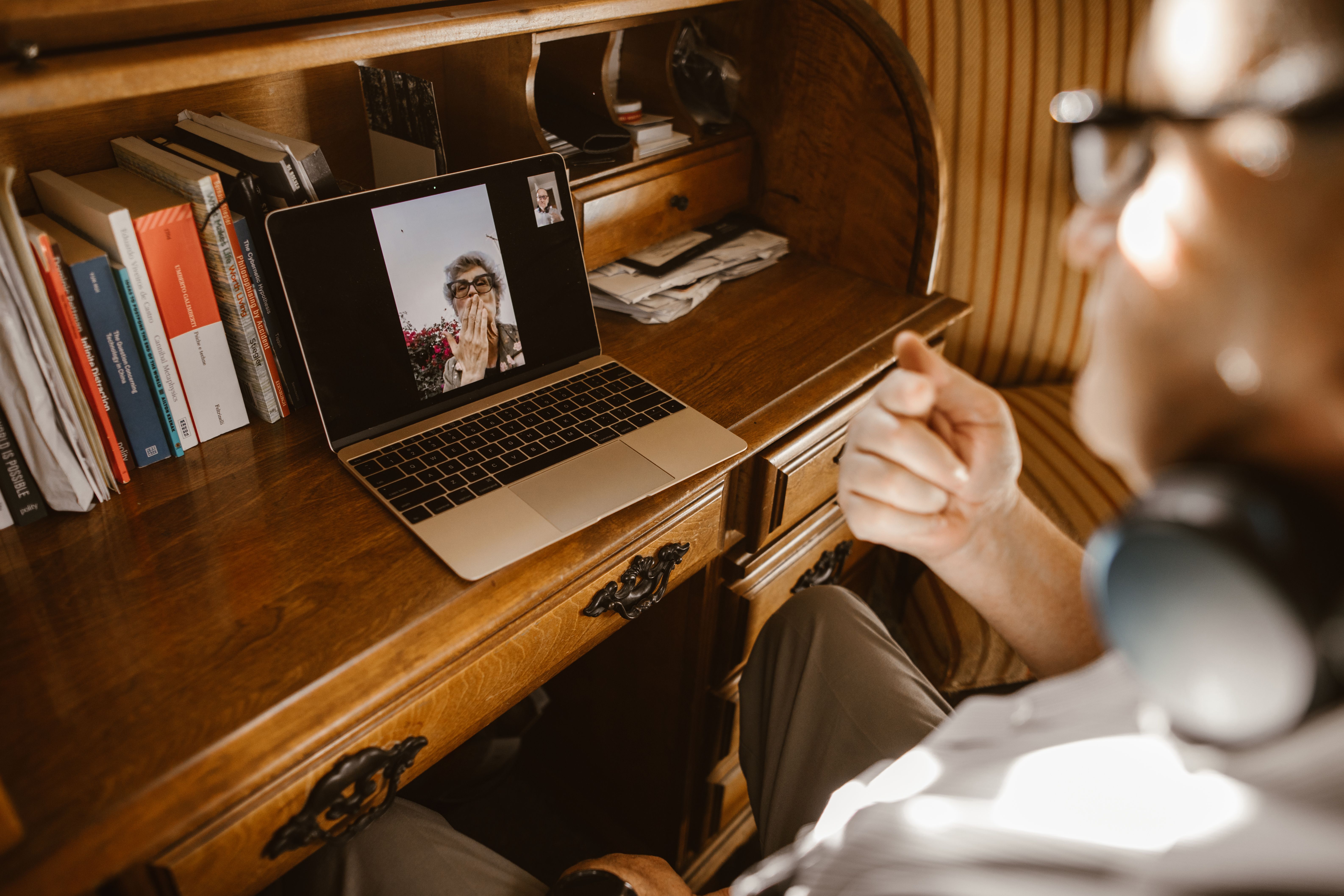 Person on a laptop video call at a desk, representing a long-distance digital relationship