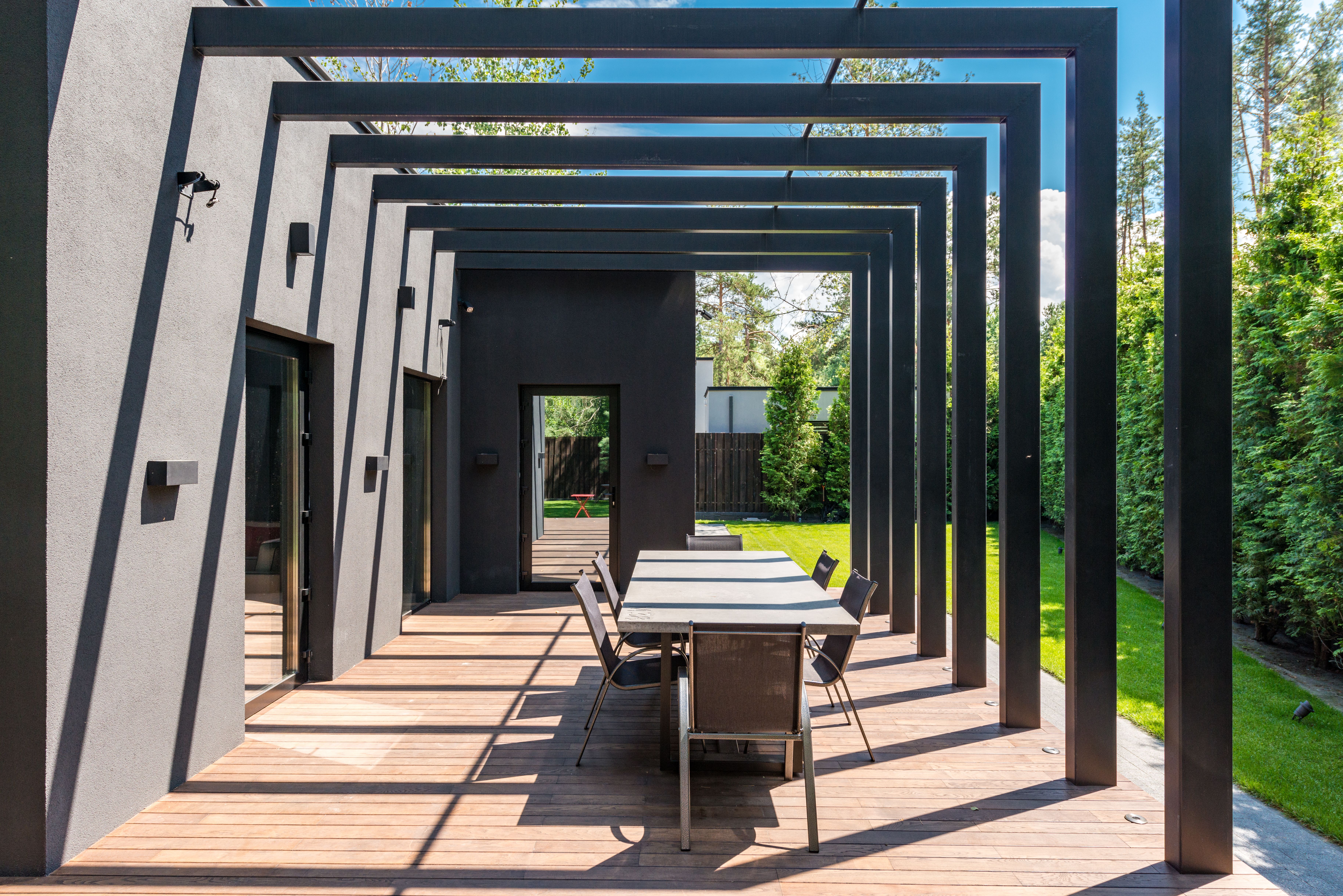 Contemporary patio with an elegant pergola structure and outdoor dining set